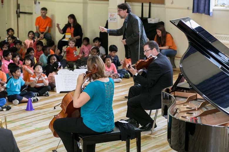 Euterpe musicians with children at an underserved school in Toronto (Image courtesy of Euterpe: Music is the Key)